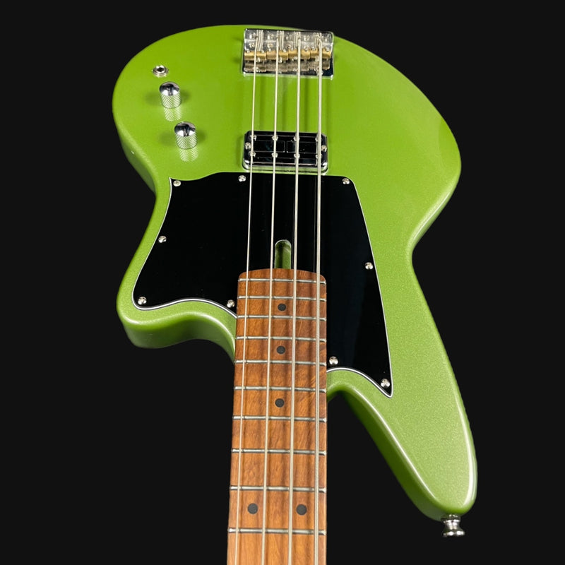 Green electric bass guitar with a black background