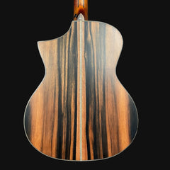 Close-up of a guitar's wooden back and neck on a black background