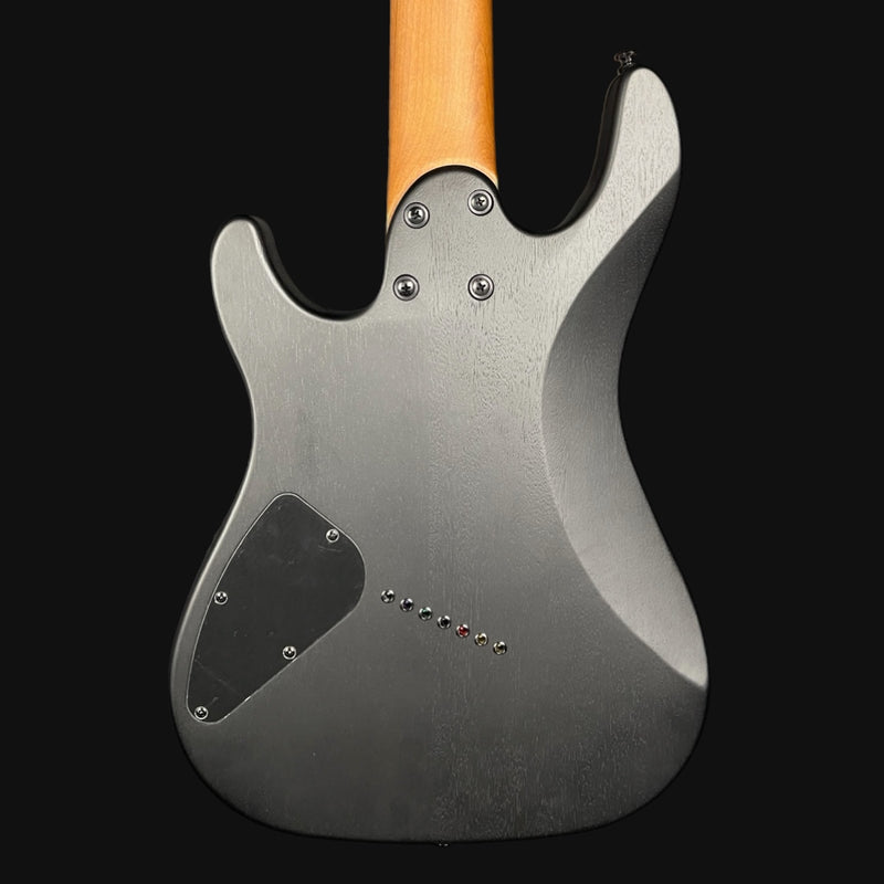 Back view of a matt black electric guitar with a wooden neck on a black background
