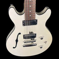 White electric guitar with a black pickguard on a black background