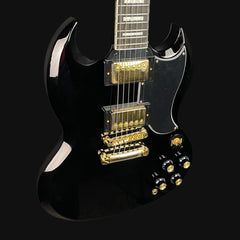 Black electric guitar with gold hardware on a black background