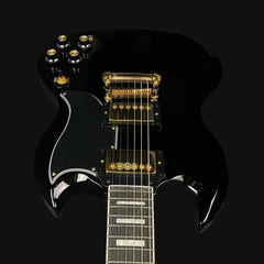 Black electric guitar with gold hardware on a black background