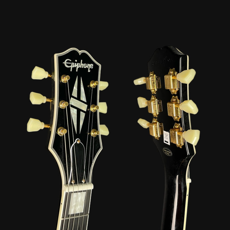 Close-up of two guitar heads with Epiphone branding on a black background