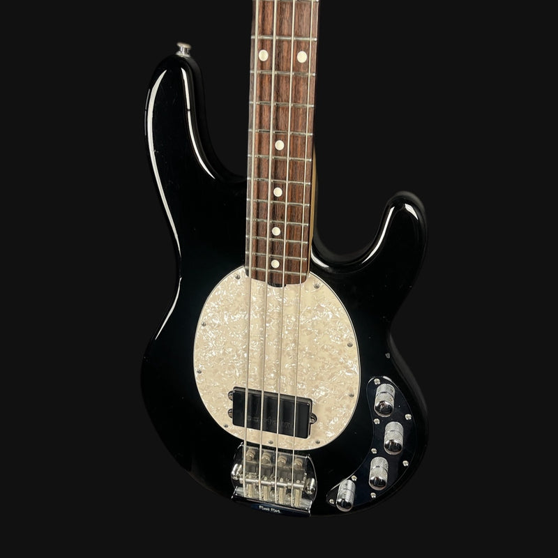 Black electric bass guitar with a unique body design on a black background