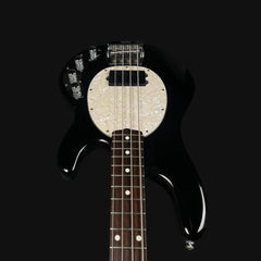 Black electric bass guitar with a white pickguard on a black background