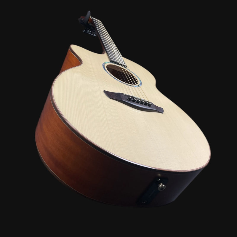 Acoustic guitar with a wooden body and white pickguard on a black background