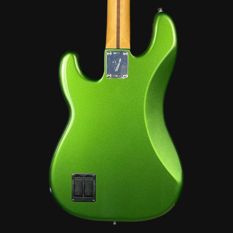 Green electric guitar with a black pickguard on a white background