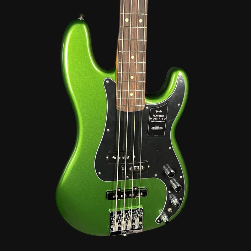 Green electric bass guitar on a black background