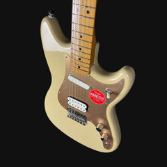 Beige electric guitar with a red Fender sticker on a black background