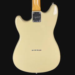 Back view of a cream-colored electric guitar with a wooden neck on a black background