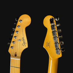 Two guitar heads with 'Squier' branding on a black background