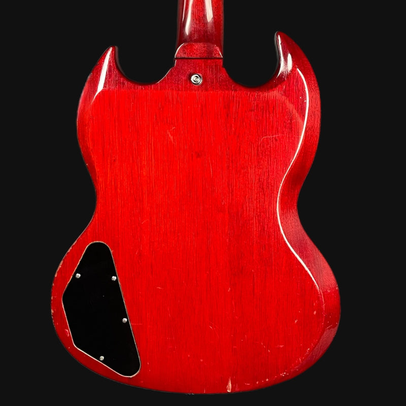 Red electric guitar body on a black background