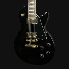 Black electric guitar with gold hardware on a black background