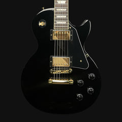 Black electric guitar with gold hardware on a black background