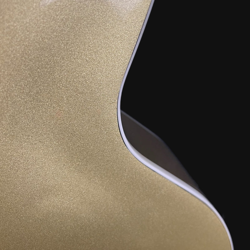 Close-up of a gold metallic surface with a black corner