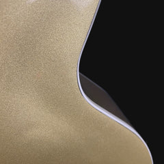 Close-up of a gold metallic surface with a black corner