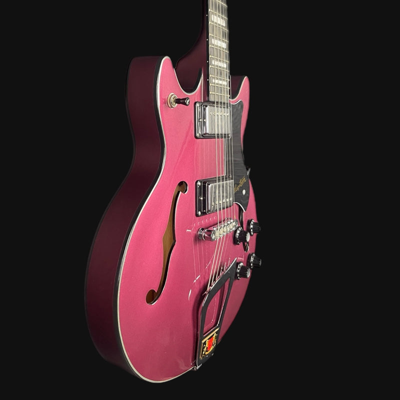 Pink electric guitar on a black background