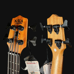 Two Kala bass guitars with headstocks and tuning pegs on a black background