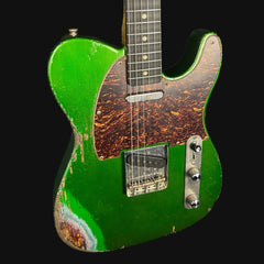 Green electric guitar with a worn finish on a black background