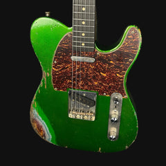 Green electric guitar with a worn finish on a black background