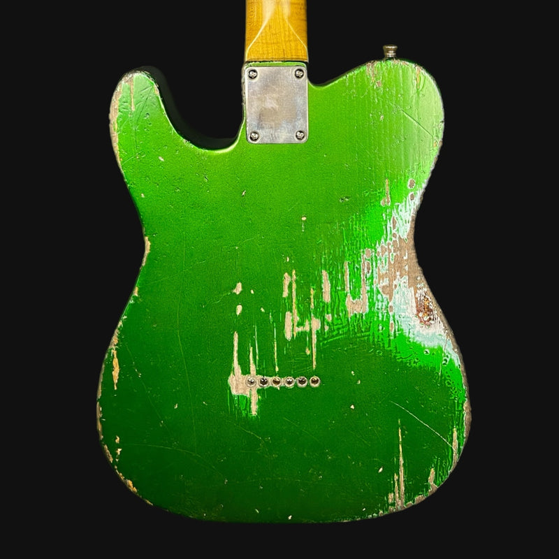 Green electric guitar body with wear and tear on a black background