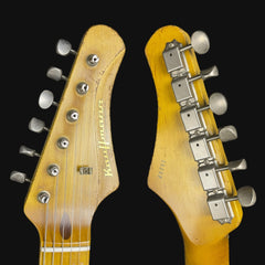 Close-up of two guitar heads with brand names on a black background