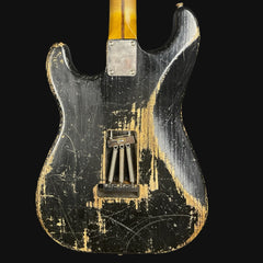 Vintage electric guitar with a worn, distressed finish on a black background