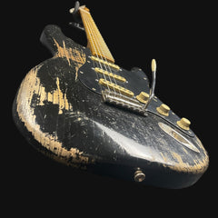 Vintage electric guitar with black and gold finish on a black background