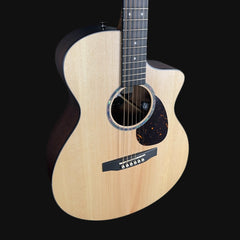 Acoustic guitar with a black pickguard on a black background