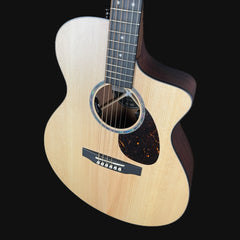 Acoustic guitar with a wooden body and dark wood neck on a black background