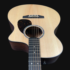 Acoustic guitar with a visible brand logo on a black background