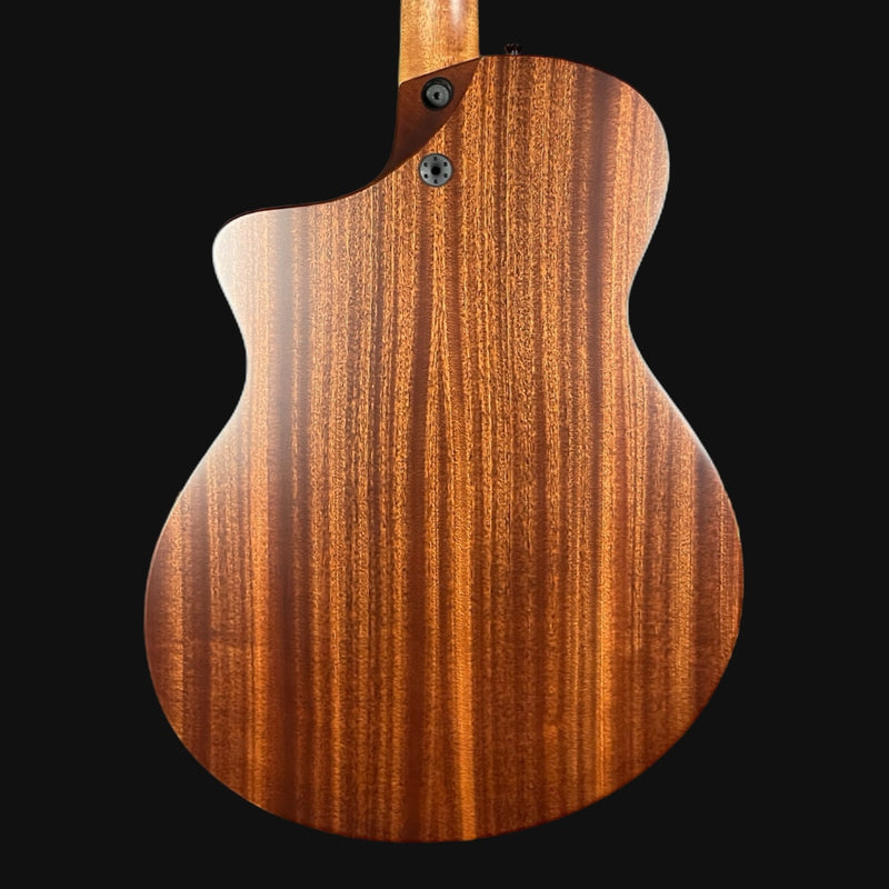Close-up of a wooden guitar body with a dark background