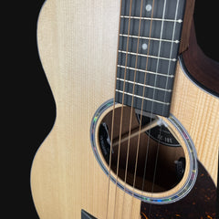 Close-up of an acoustic guitar's soundhole and strings on a black background