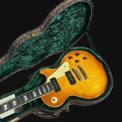 Electric guitar with a sunburst finish in an open green case on a black background