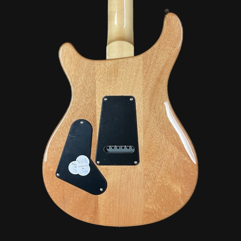Back view of a electric guitar with a natural wood finish on a black background