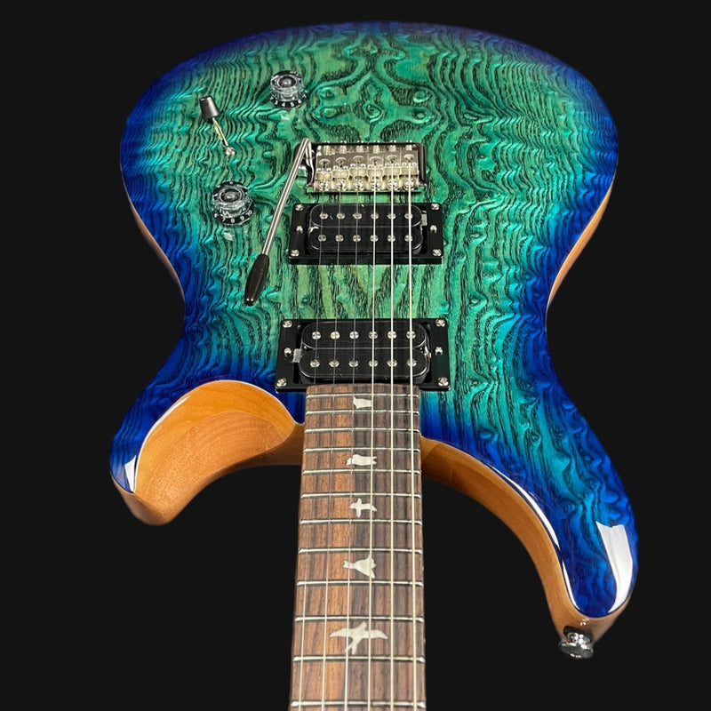 Electric guitar with a wavy blue and green finish on a black background