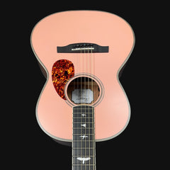 Acoustic guitar with a tortoiseshell pickguard on a black background