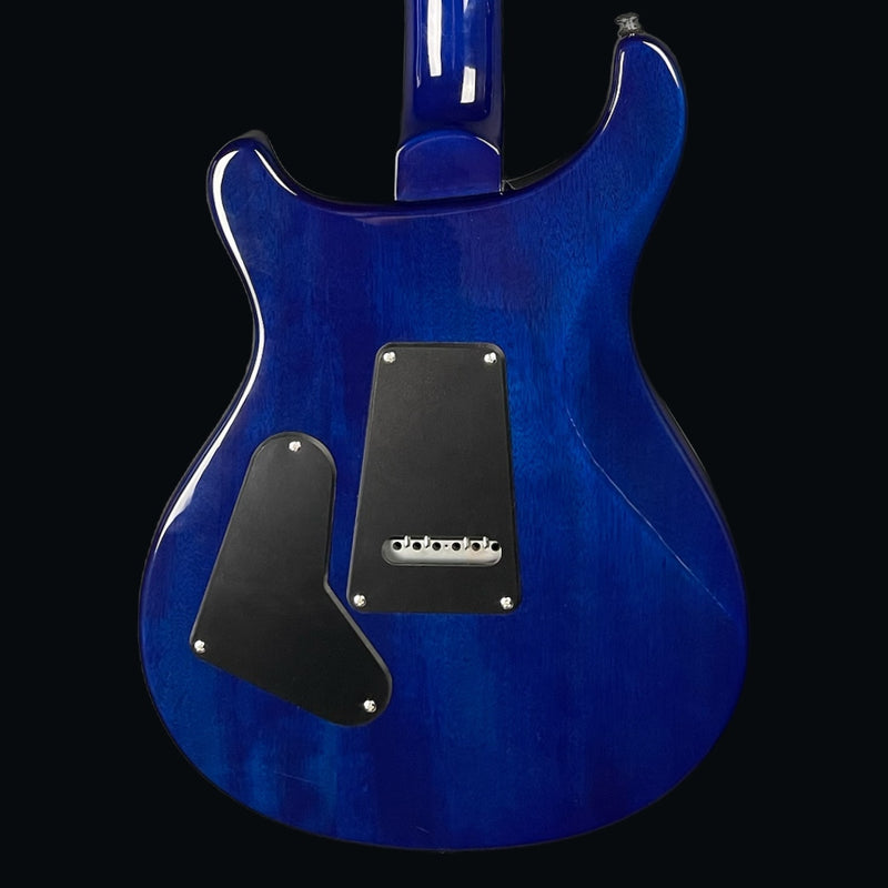 Blue electric guitar with a black pickguard on a white background