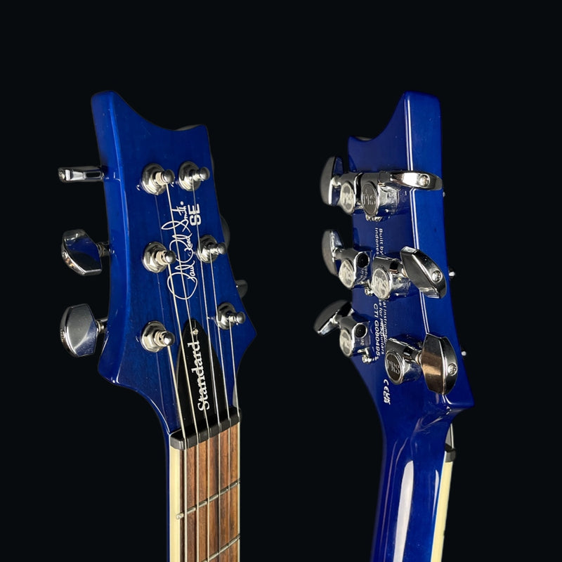 Two blue electric guitar heads with brand names on a black background