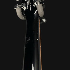 Close-up of a guitar neck with headstock on a black background
