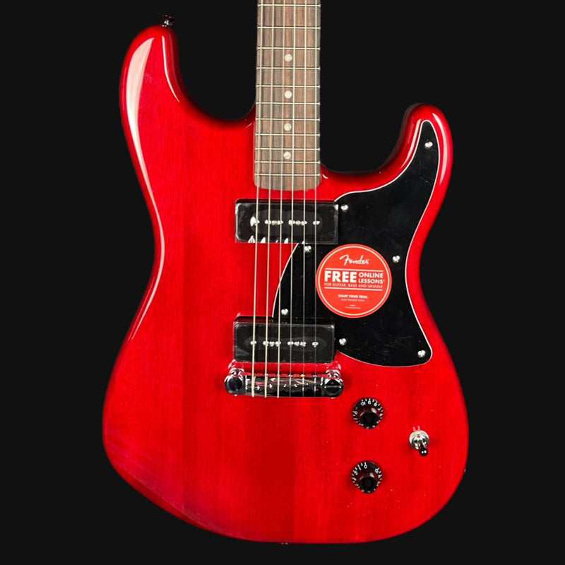 Red electric guitar with a visible Fender sticker on a black background