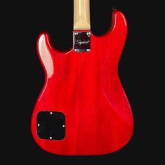 Red electric guitar body with a black pickguard on a black background