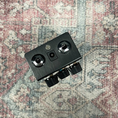 Black electronic device with multiple ports on a patterned fabric background