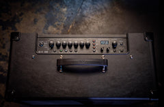Guitar amplifier with control panel on a textured surface