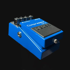 Blue compressor guitar pedal on a black background