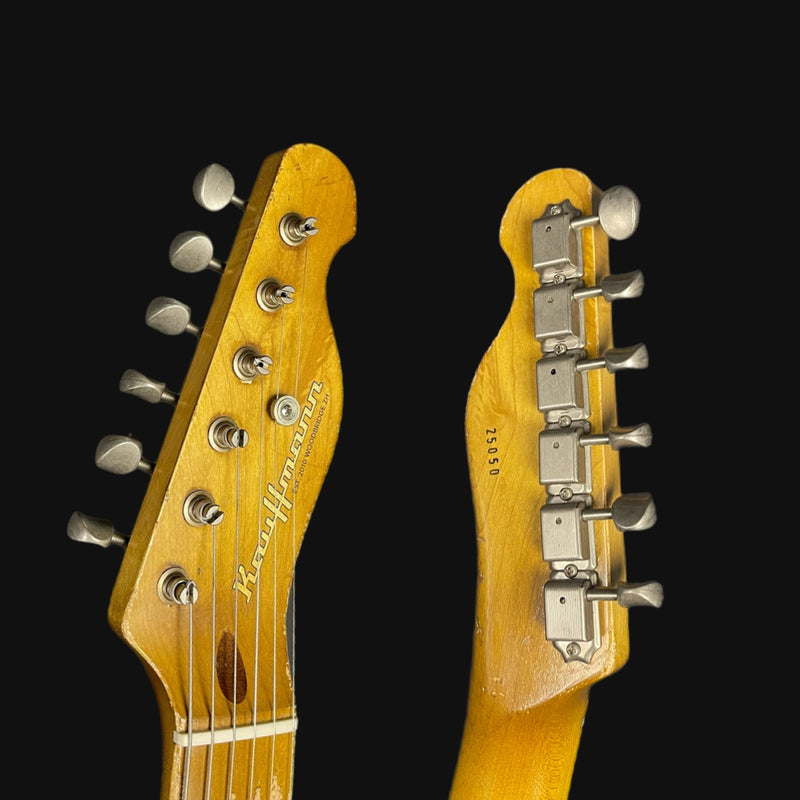 Close-up of two guitar heads with brand names on a black background