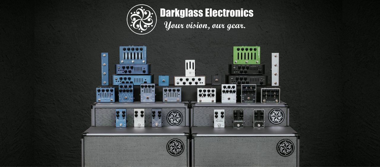 Amplifiers by the brand Darkglass. On top of the amplifiers there are darkglass pedals and synths standing on top of the amplifiers.